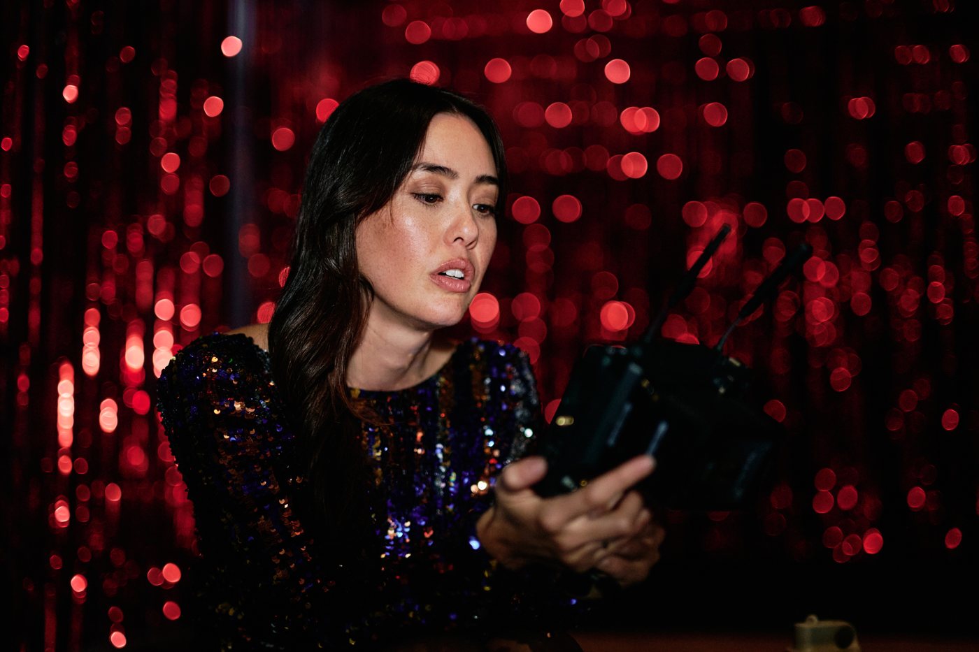 Kat Mills Martin in a sequined top against red sparkling lights