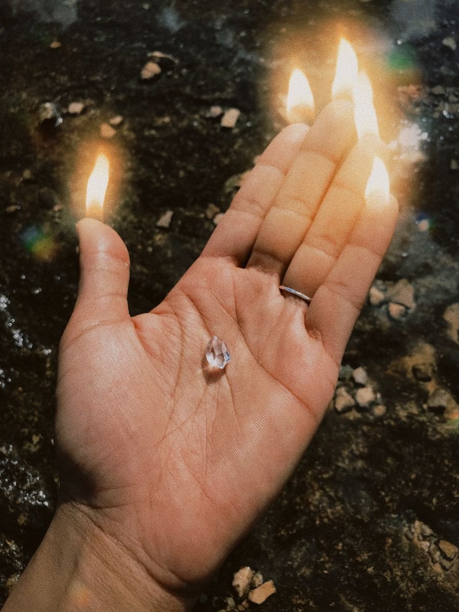 An open hand with candle flames burning from the fingertips
